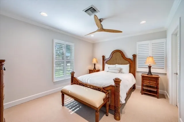 King primary bedroom with plantation shutters and water views